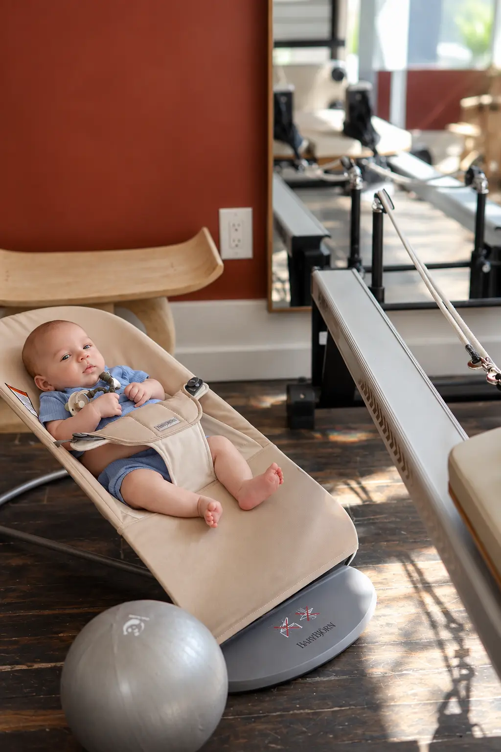 Baby resting in a bouncer beside the reformer in Leslieville