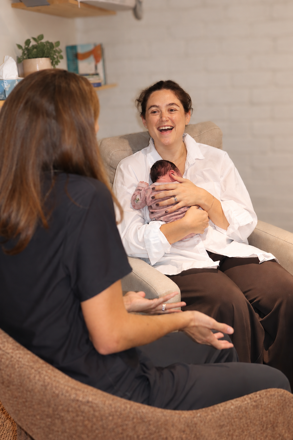 A lactation consultant talking with a parent and her baby